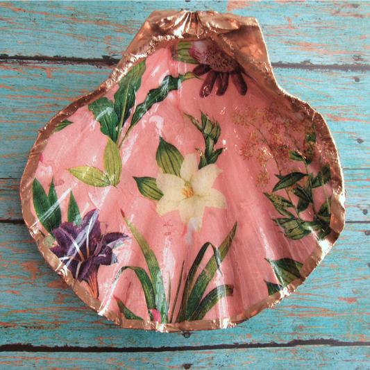 Decorative shell with floral design on a wooden surface